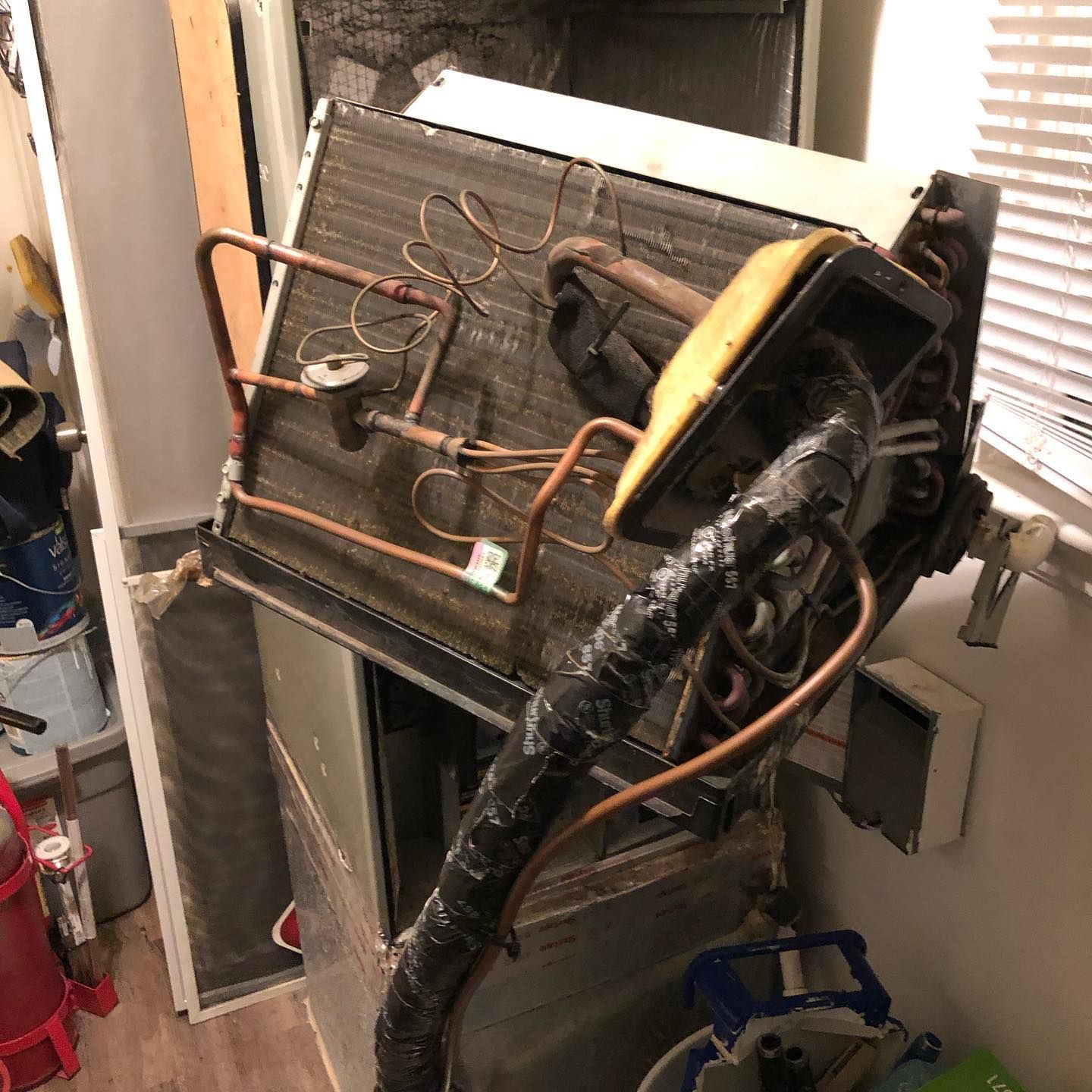 A broken air conditioner is sitting on the floor in a room.