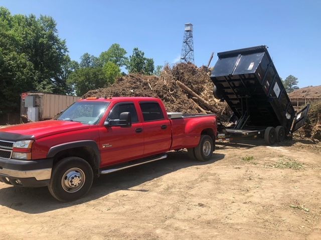 A red truck is loaded with a lot of junk in the back.
