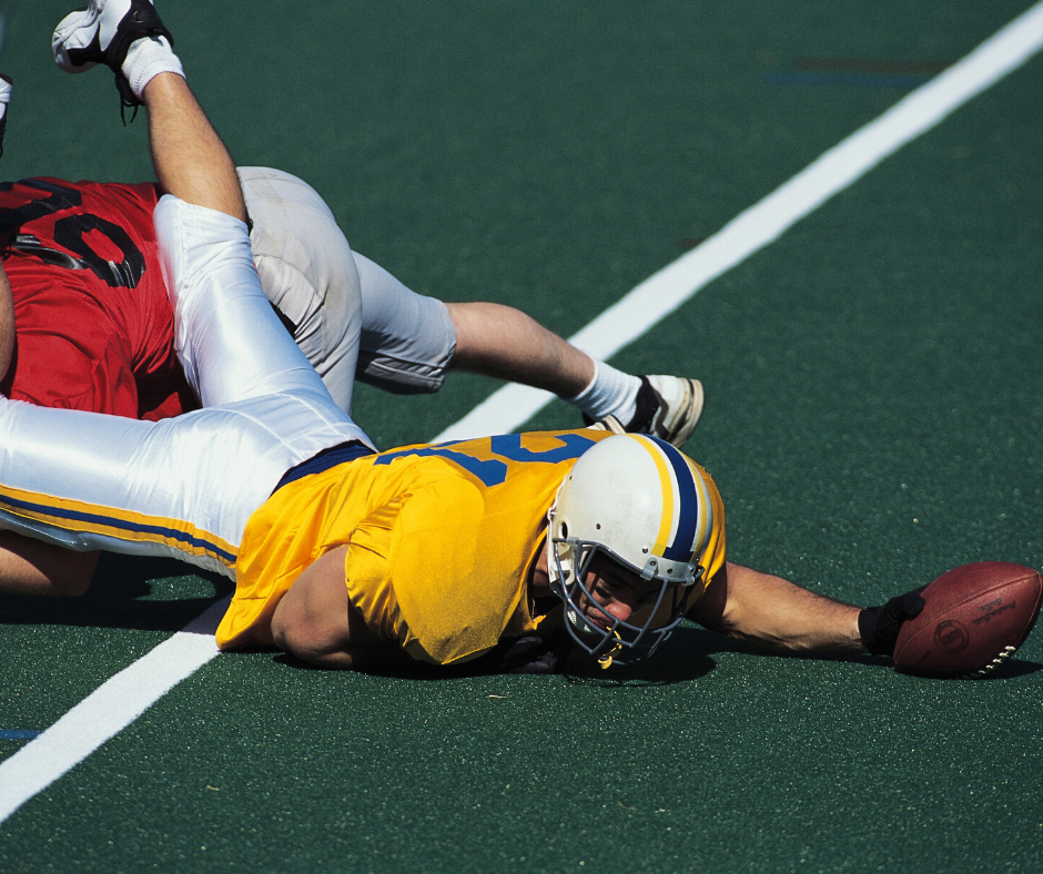 Football Player Holding a Ball on the Ground — Green Bay, WI — AnSer