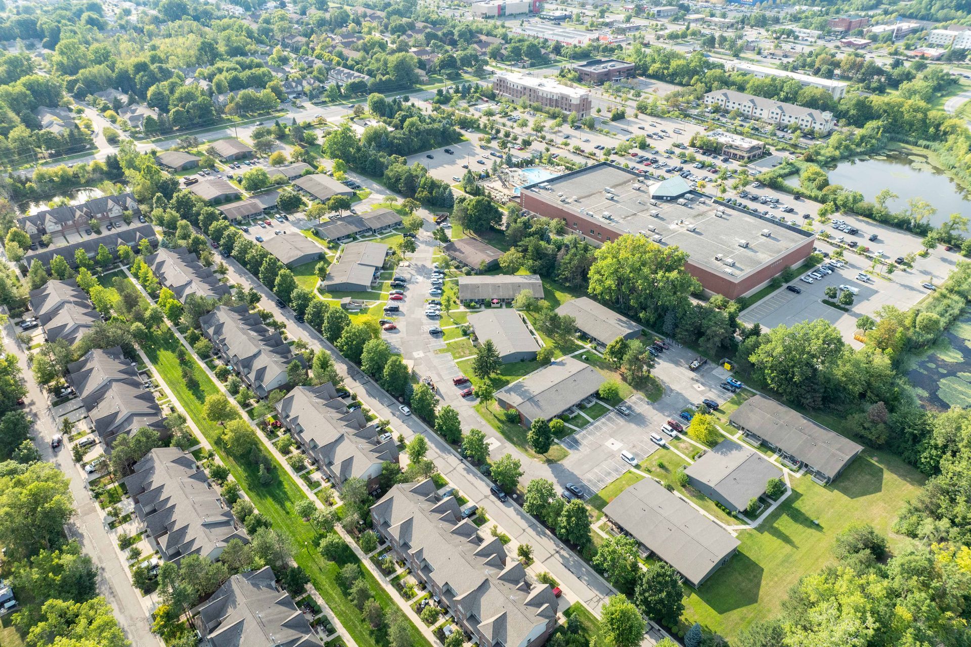 Aerial view of a residential area with townhouses, office buildings, parking, and green spaces.