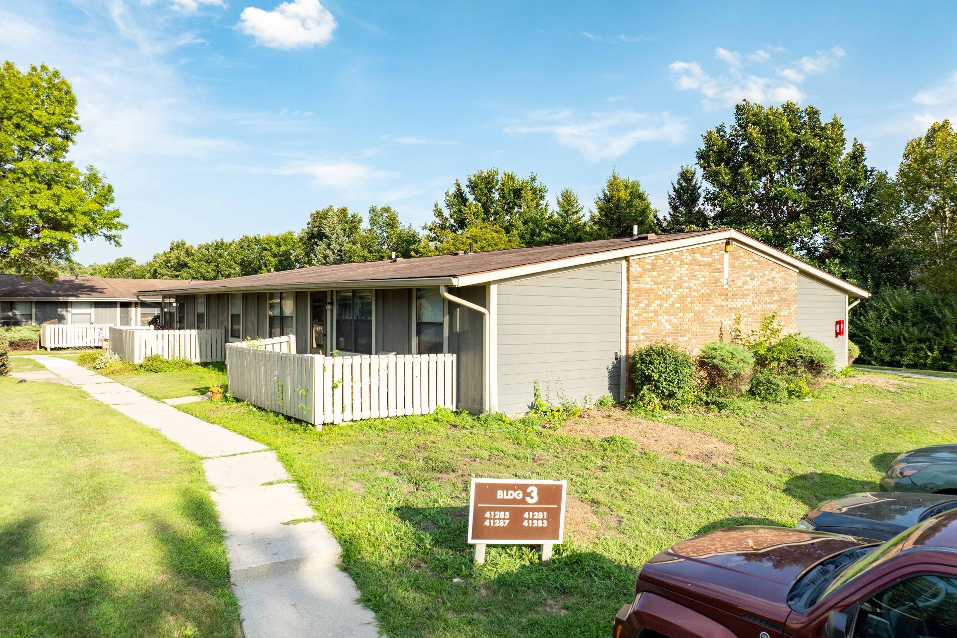 Exterior of a row of apartments with a sign indicating 