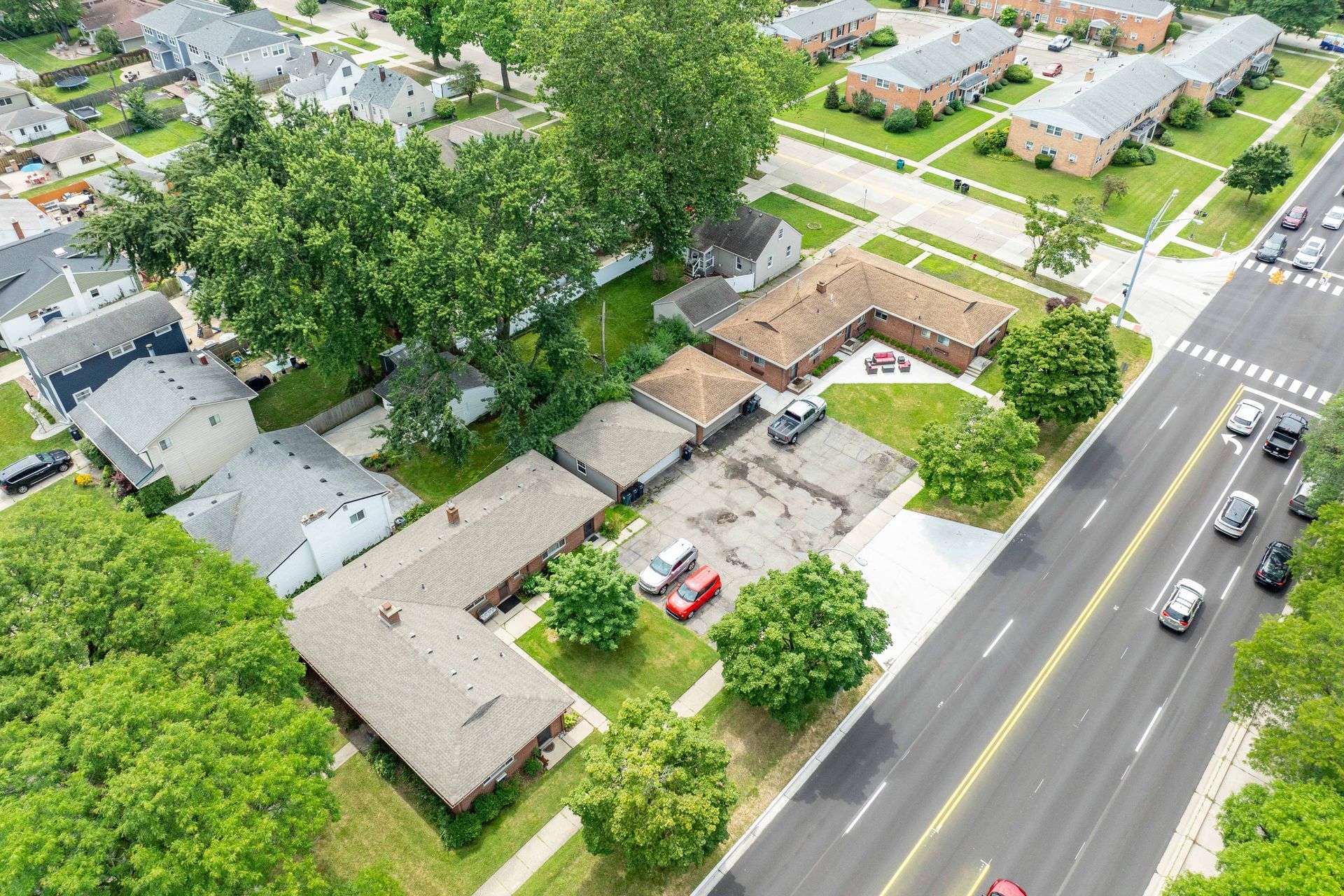 Aerial view of residential buildings and a street with cars.