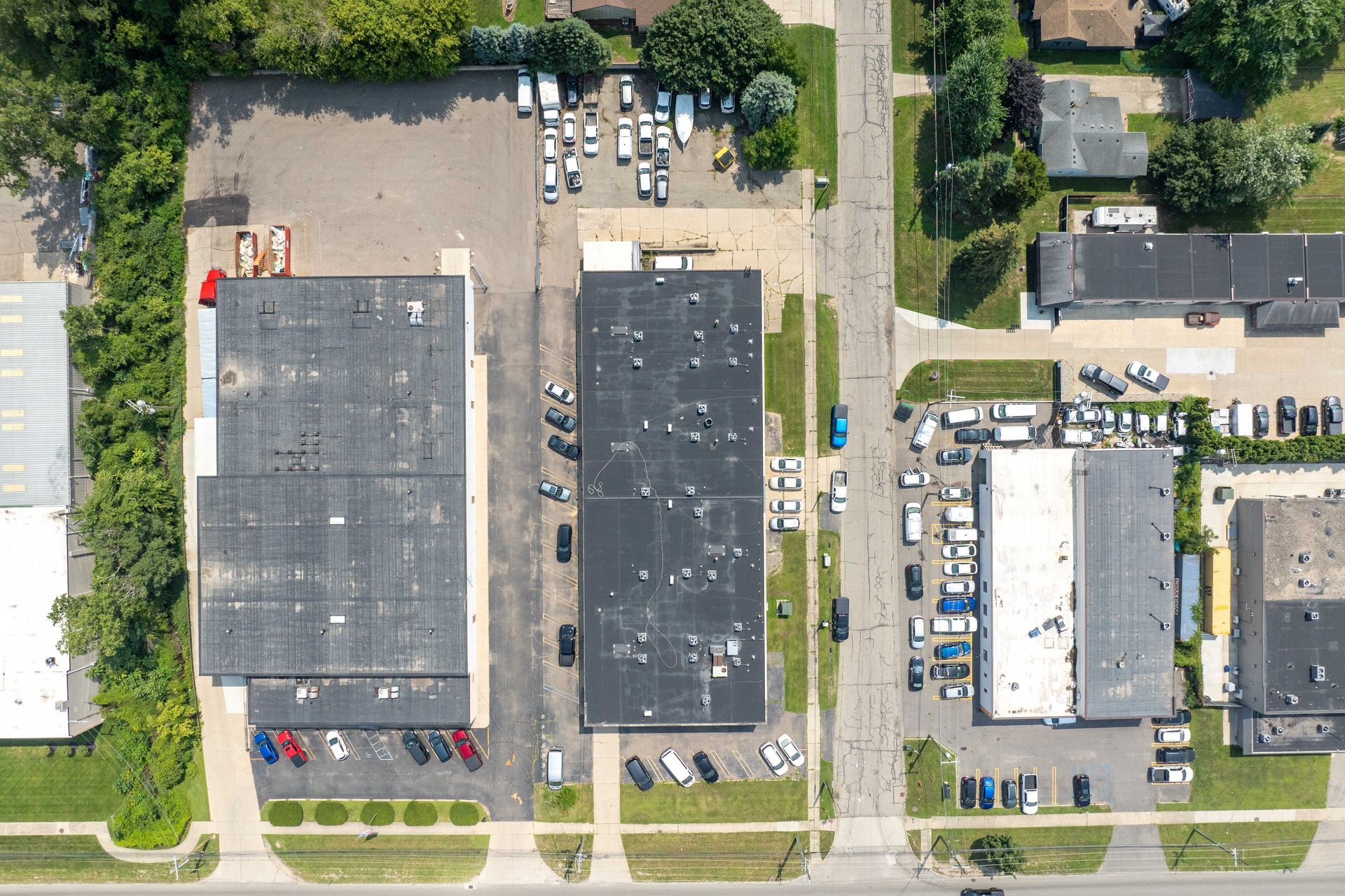 Aerial view of commercial buildings with parking, near a street.