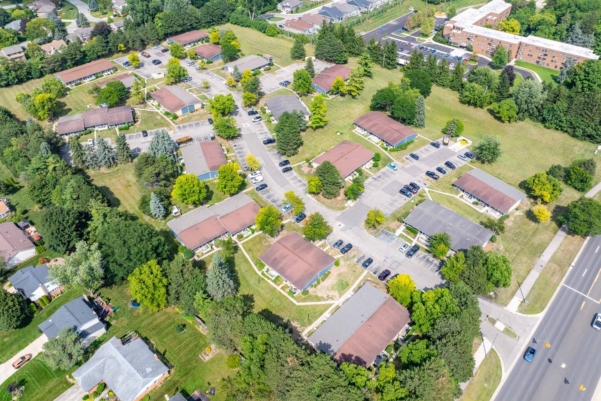 Aerial view of a residential complex with numerous buildings, parking, and green spaces.