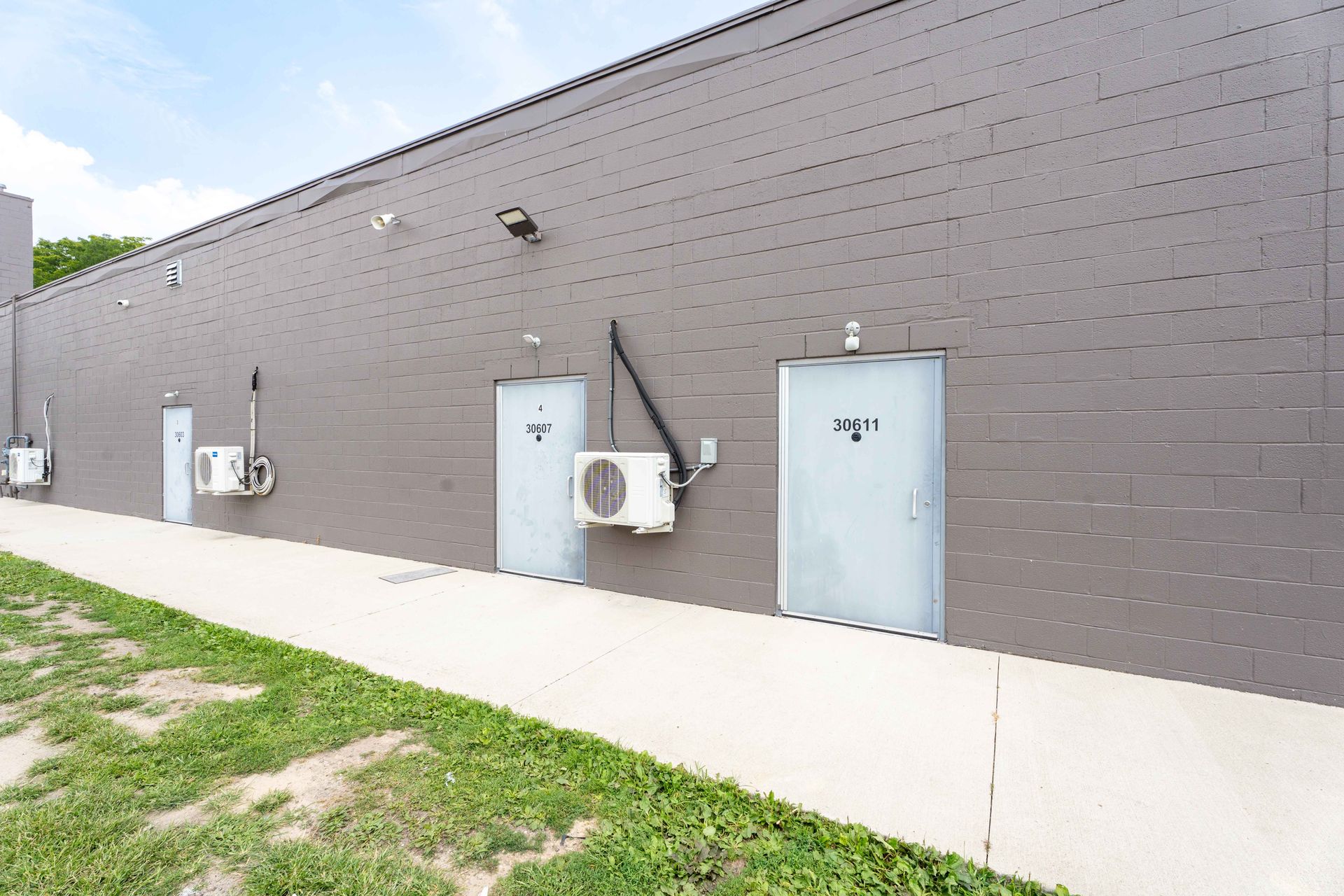 Gray brick building with doors labeled 