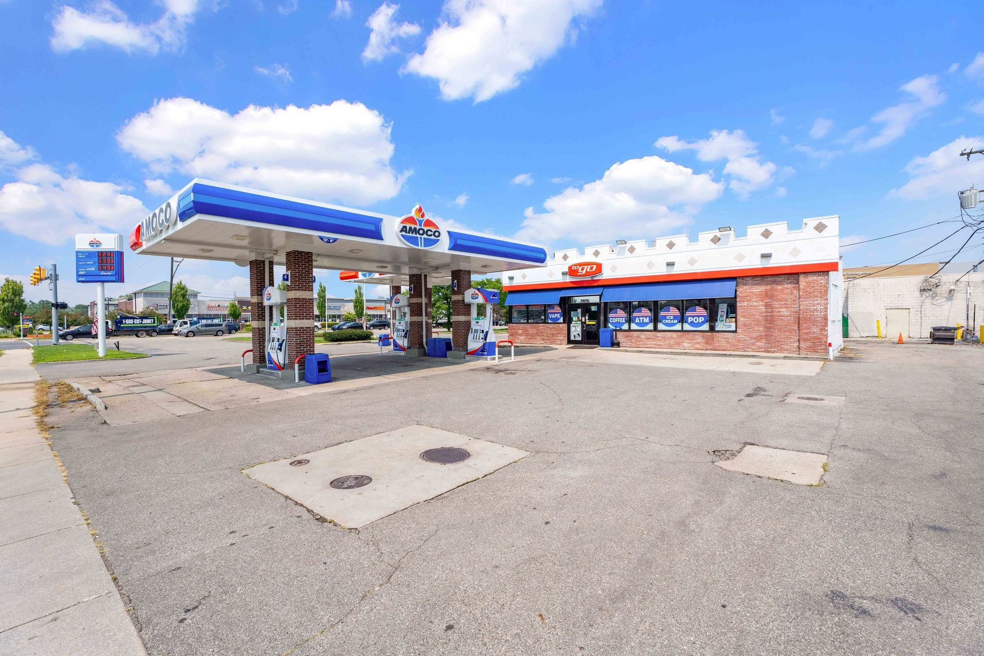 Gas station with canopy and convenience store on a bright, sunny day.