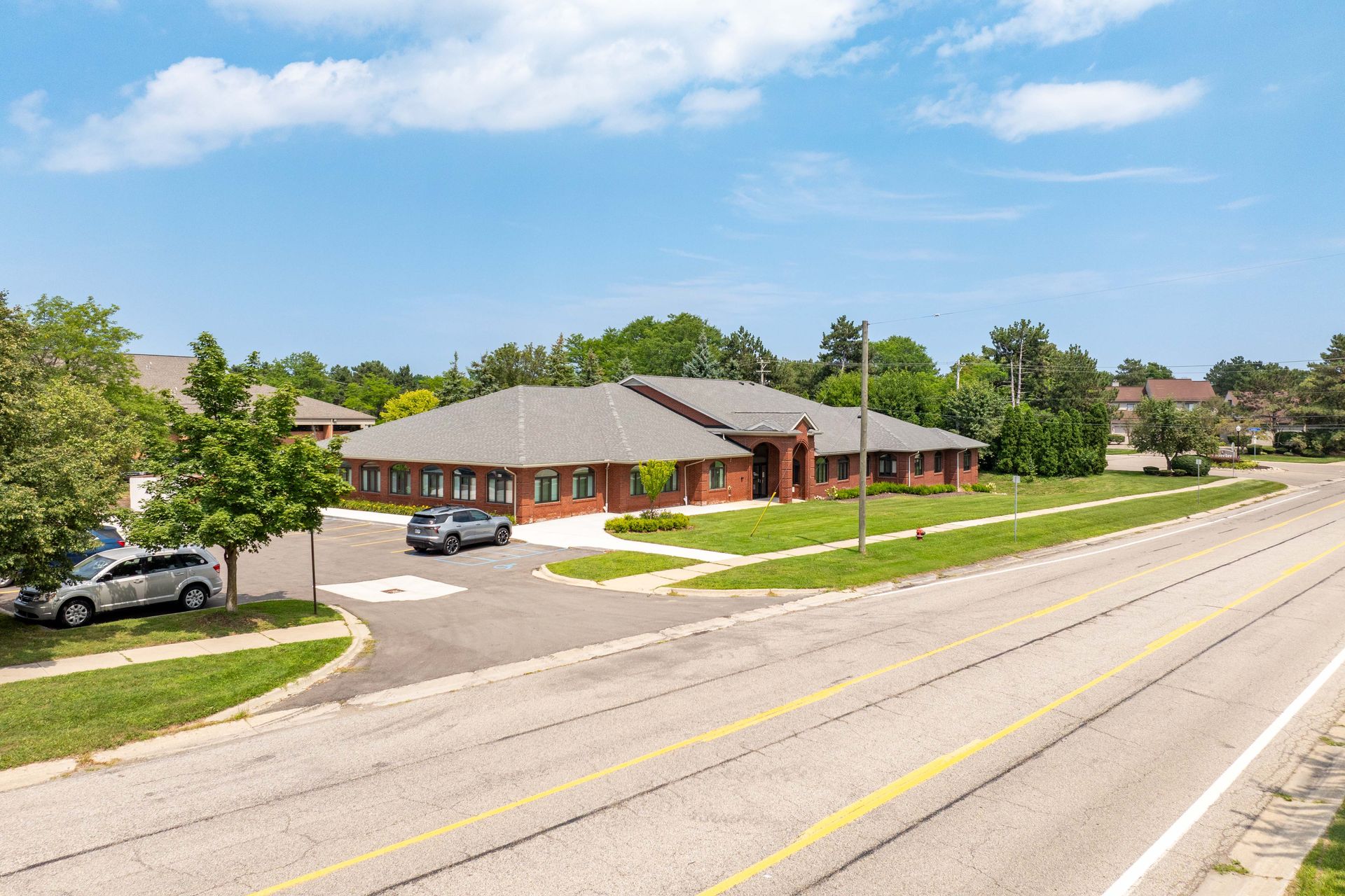 Brick building with parked cars on a sunny day.