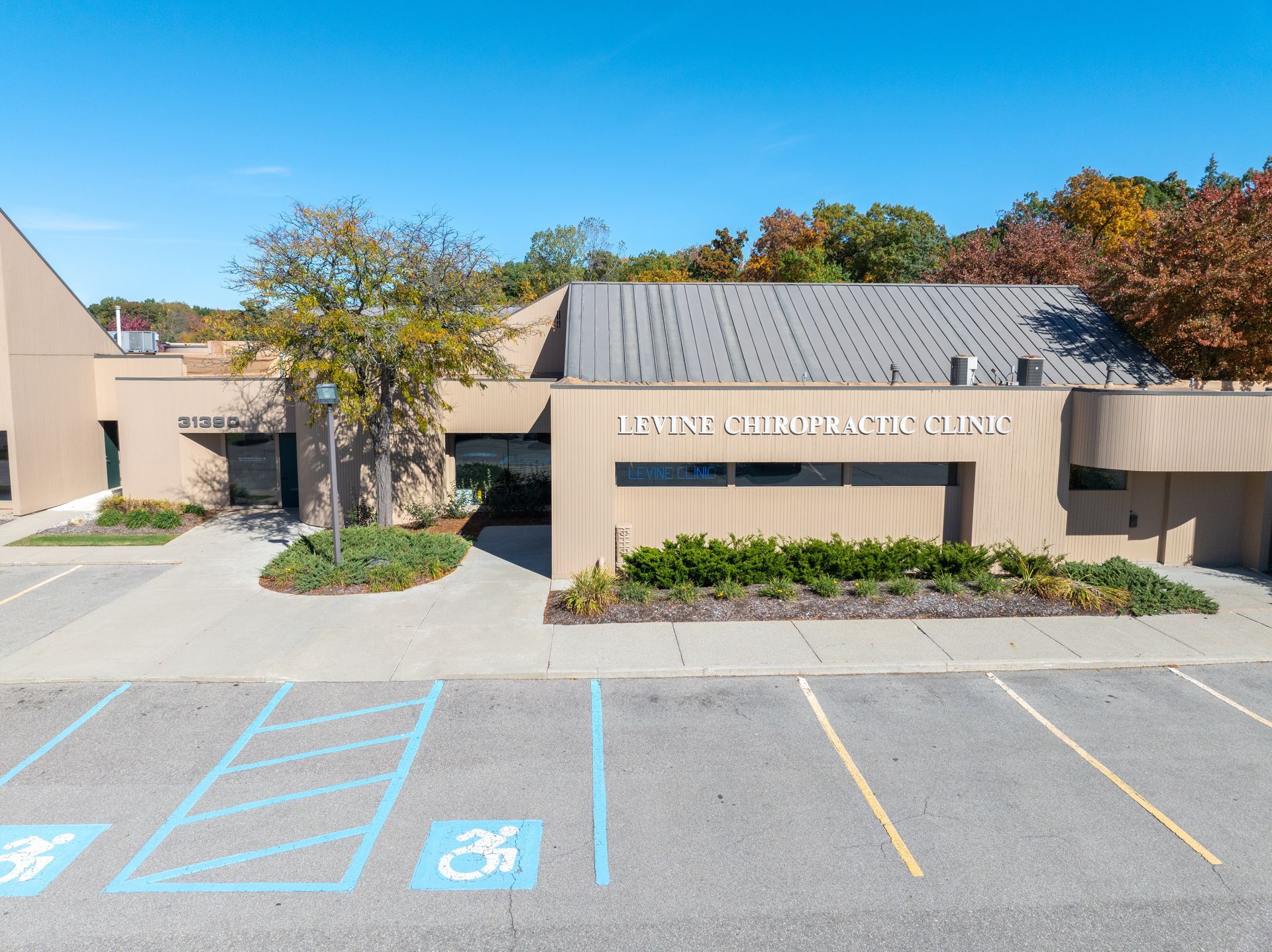 Exterior of Lytle Chiropractic Clinic on a sunny day; beige building with parking spots.