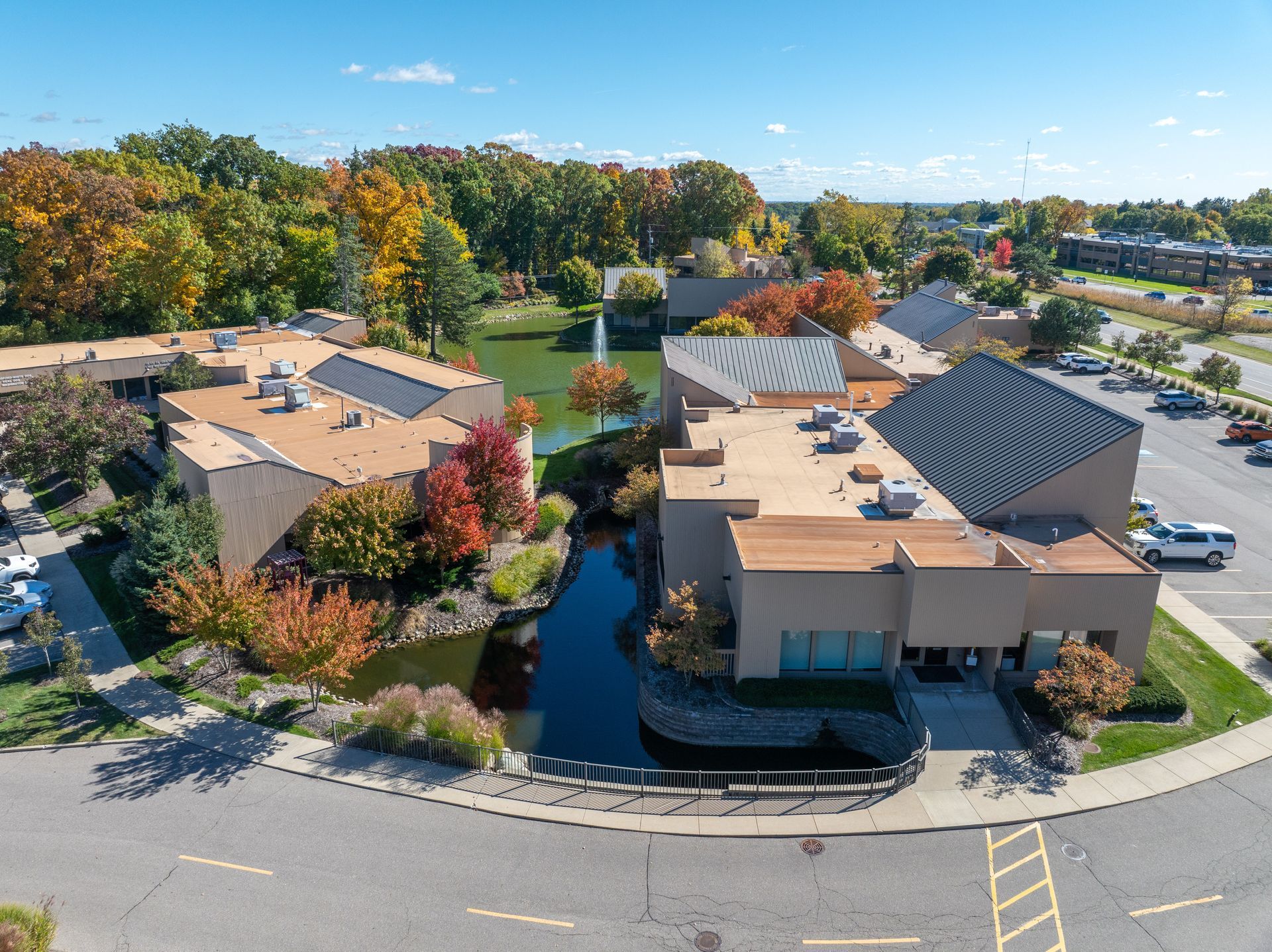 Office complex with pond and fall foliage.