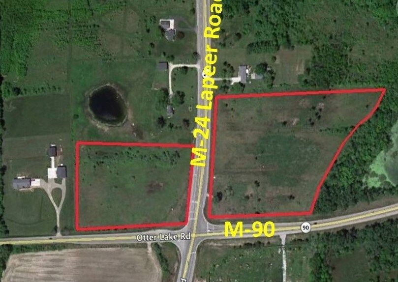 Aerial view of two plots of land adjacent to M-24 and M-90 roads. Marked in red. Green fields and trees.