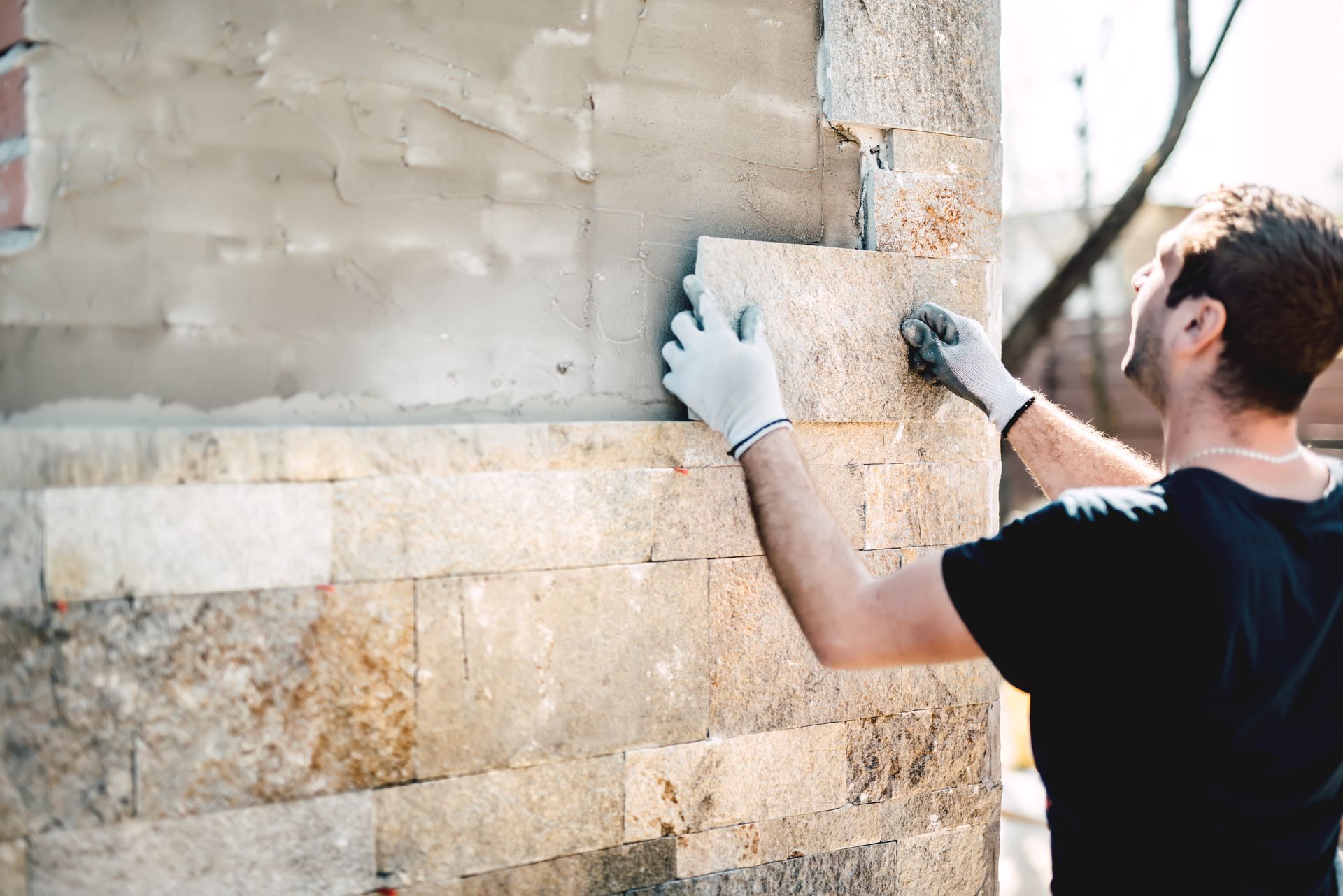 a man is installing a tile on a brick wall .