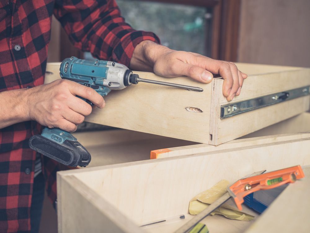 A Carpenter Is Building A Drawer In His Workshop — Prime Edge Joinery Pty Ltd in Flinders, NSW