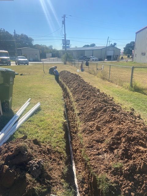 A man is digging a hole in the ground in a yard
