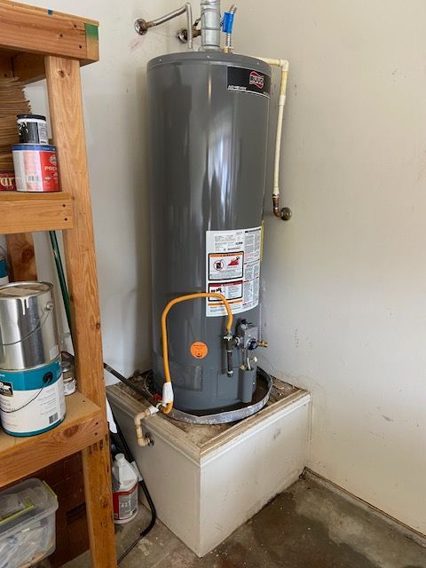 A water heater is sitting on top of a white box in a room