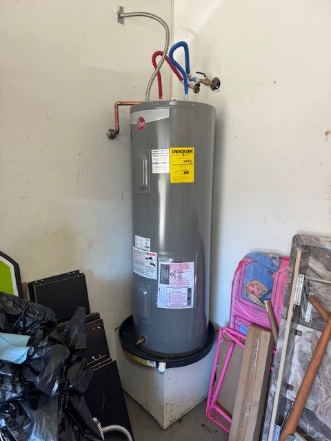A water heater is sitting in the corner of a room