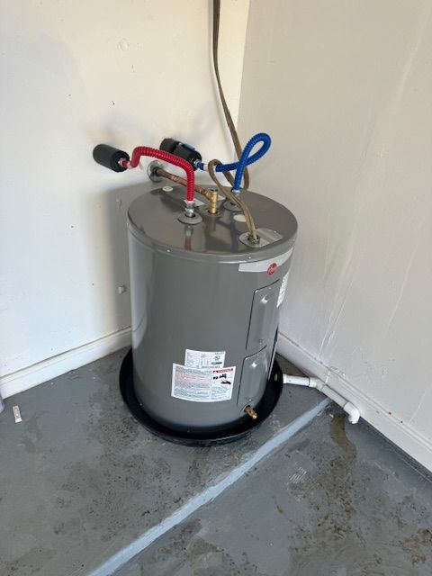A water heater is sitting in a corner of a room