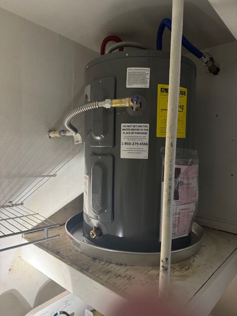 A gray water heater with a yellow sticker on it
