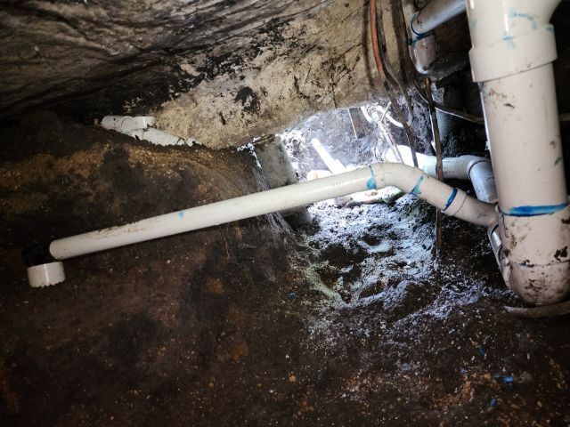A close up of a drain pipe in a basement