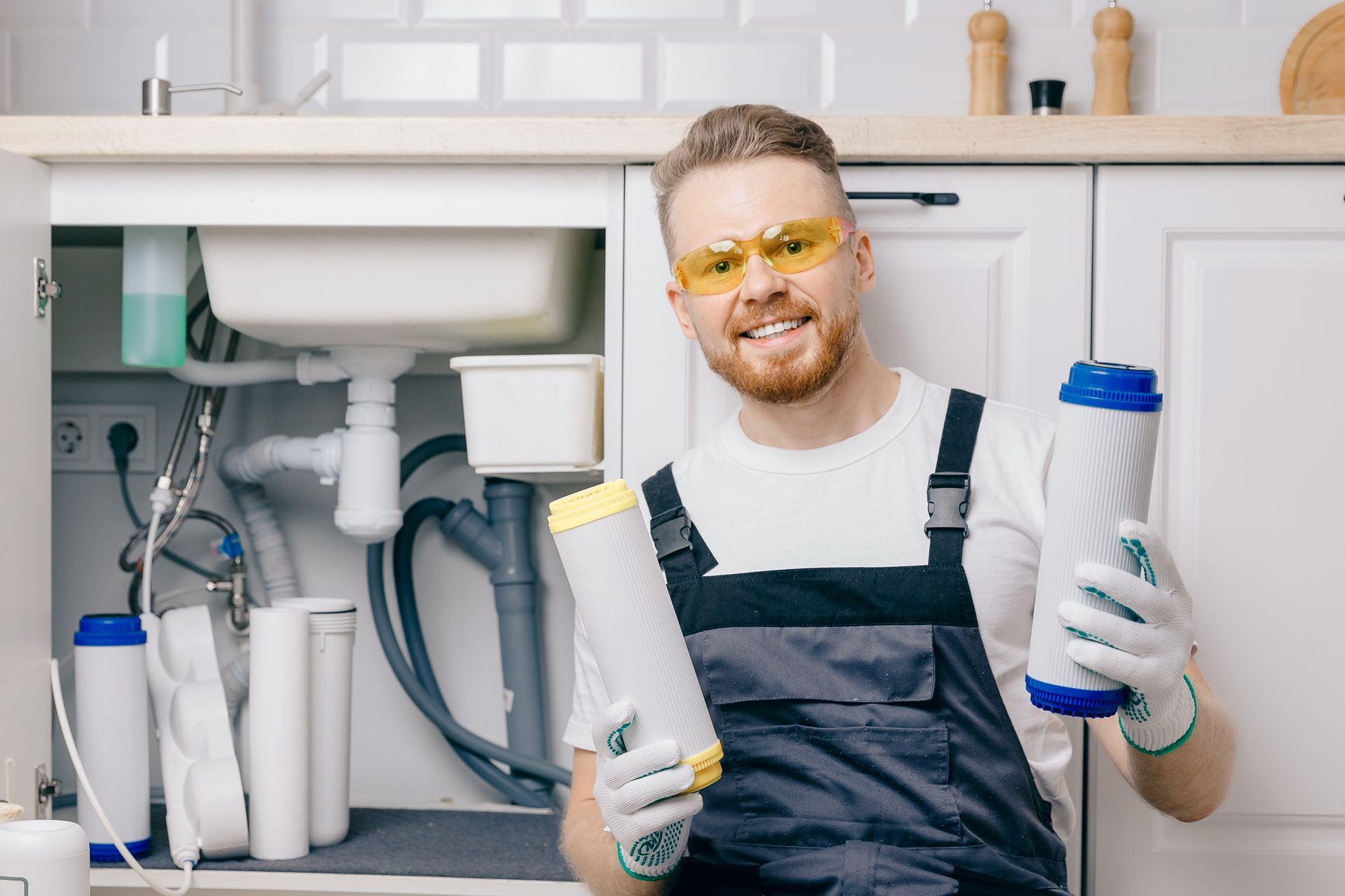 A man is holding a filter in front of a sink in a kitchen