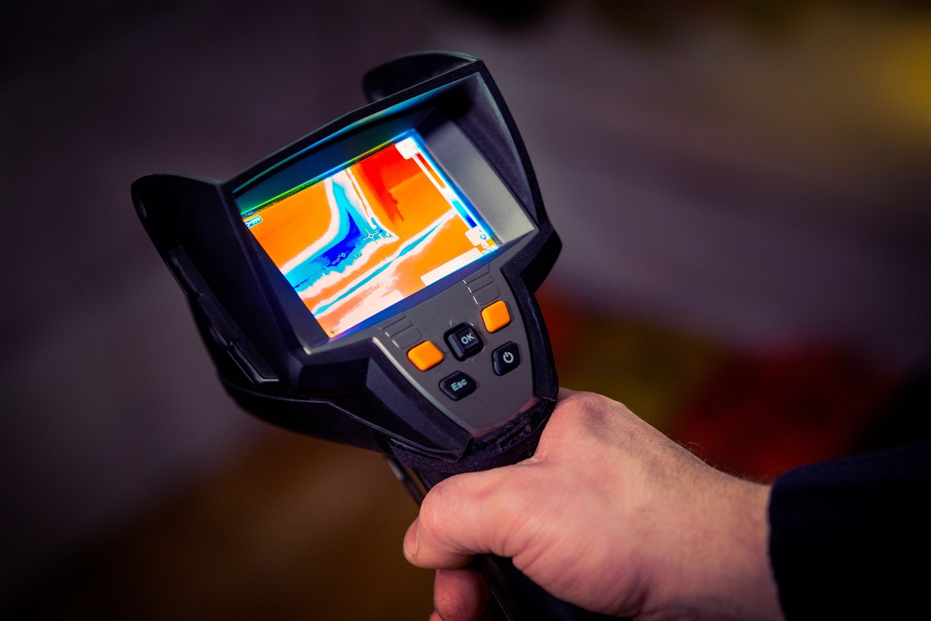 A person is holding a thermal camera in their hand