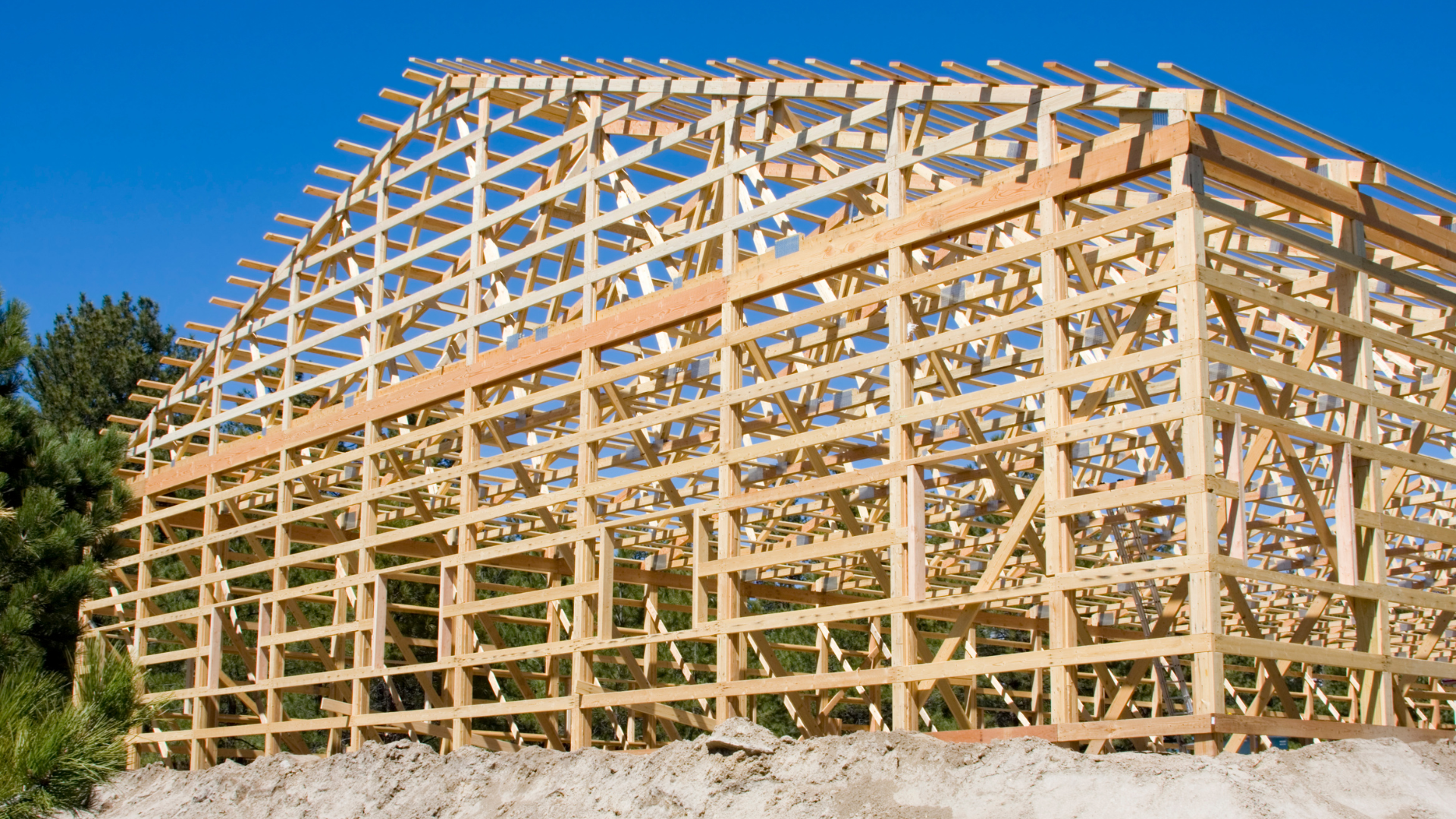 A large wooden structure is being built with a blue sky in the background.