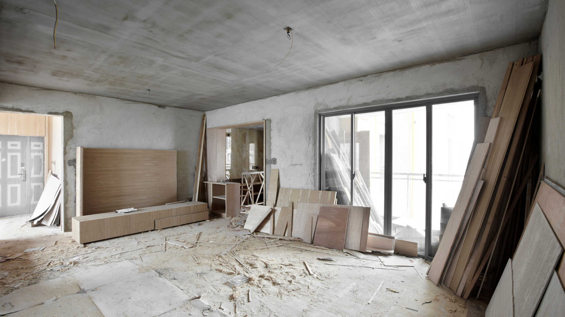 An empty room with a lot of wooden pieces on the floor.