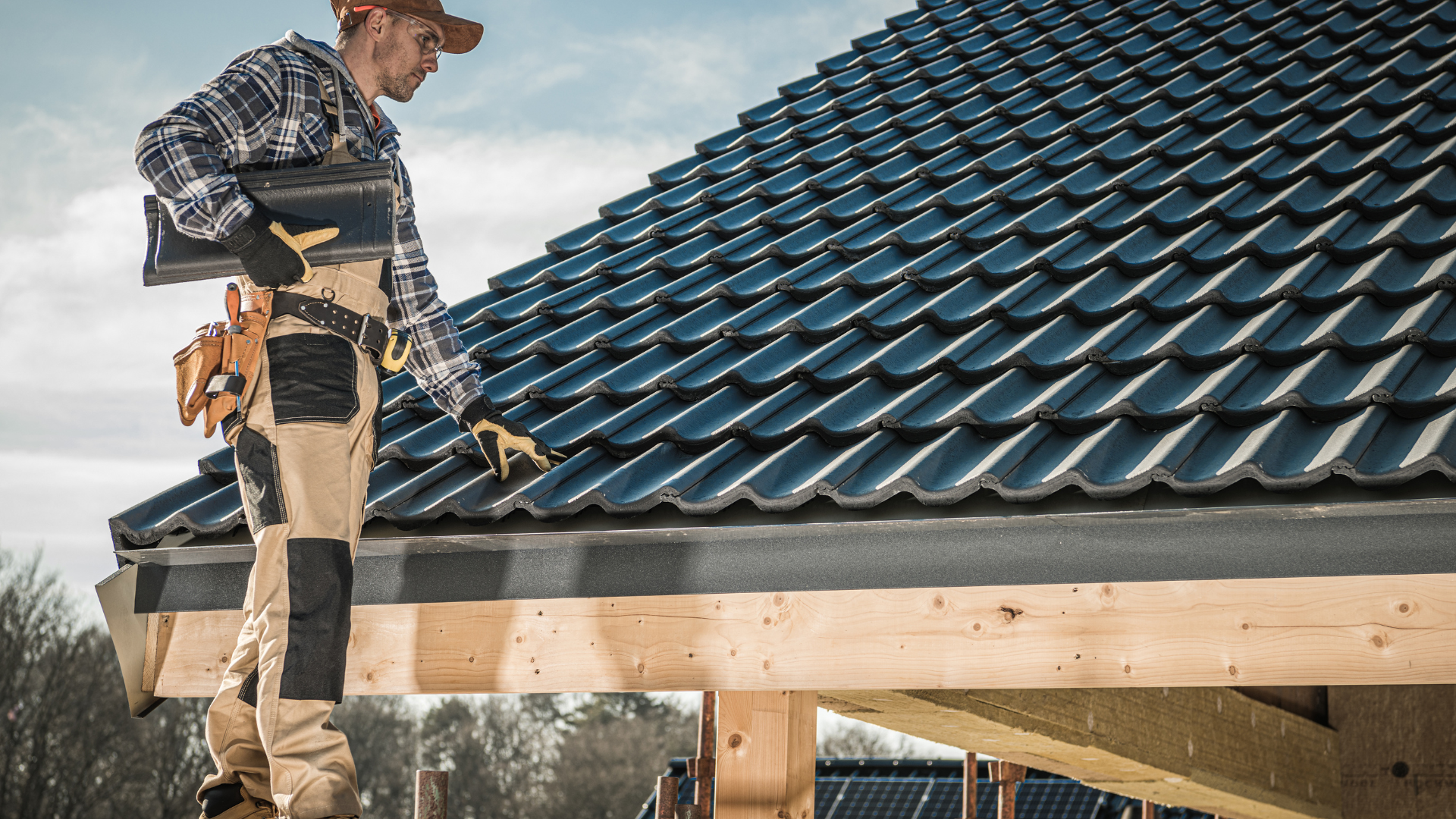 A man is standing on top of a tiled roof.