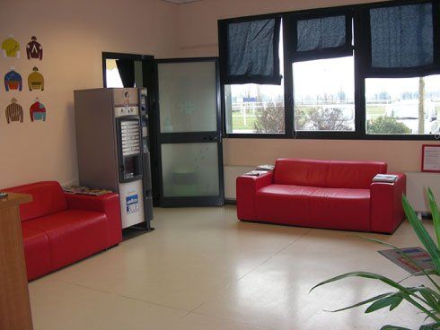 sala di attesa con due divani rossi