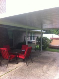 A patio with a table and chairs under a canopy.