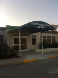 A white building with a green awning over the entrance.