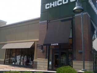 The front of a chico's store with a black awning.