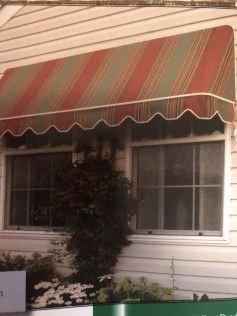 A window with a red and green awning over it.