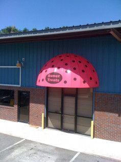 A store front with a red awning that looks like a strawberry.