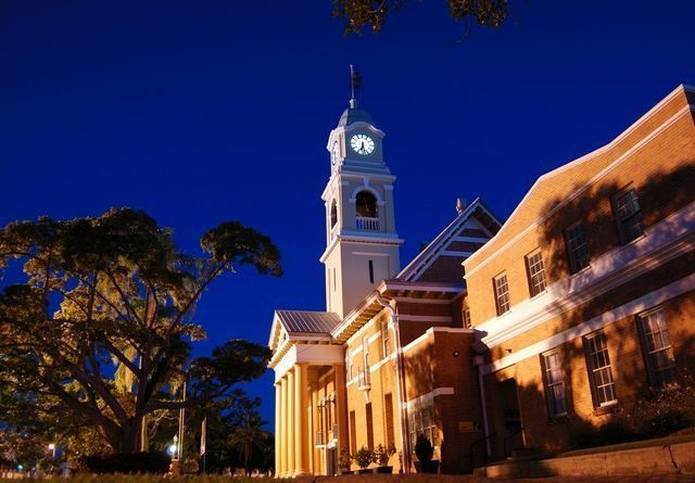A Large Building with A Clock Tower at Night — All Steel Homes in Maryborough, QLD