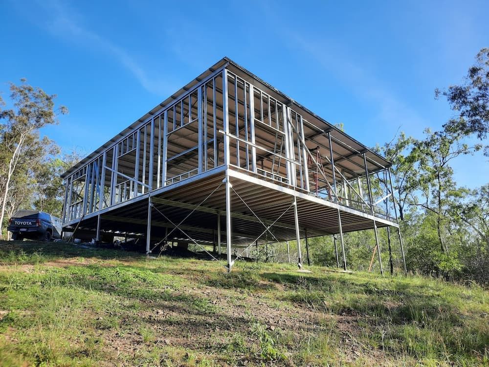 A House Is Being Built on A Hill with A Car Parked in Front of It — All Steel Homes in Branyan, QLD