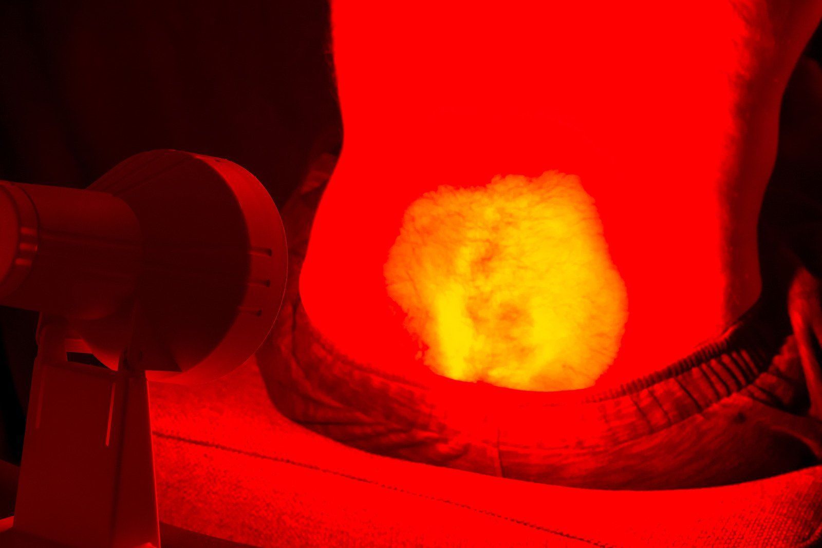 A person is getting a red light treatment on their stomach.