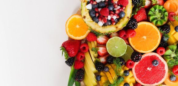 A white plate topped with a variety of fruits and berries.