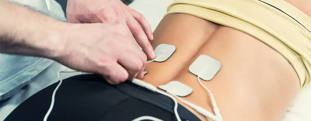 A person is getting a massage with electrodes on their back.