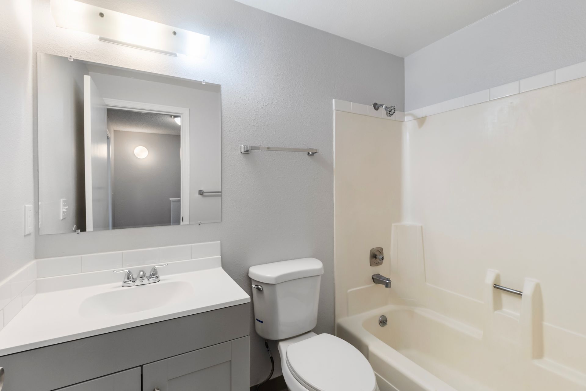 A bathroom with a toilet , sink , and bathtub.