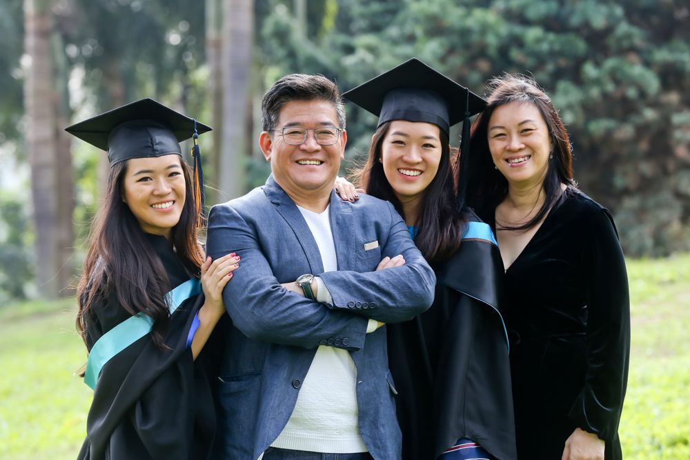 A man and two women in graduation caps and gowns are posing for a picture.