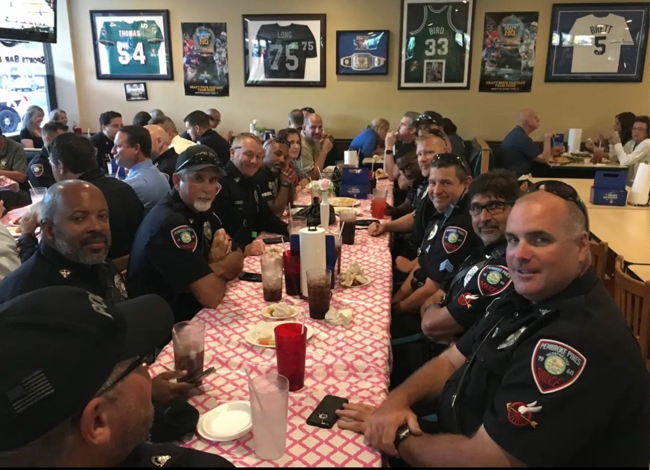 A group of police officers are sitting at a long table