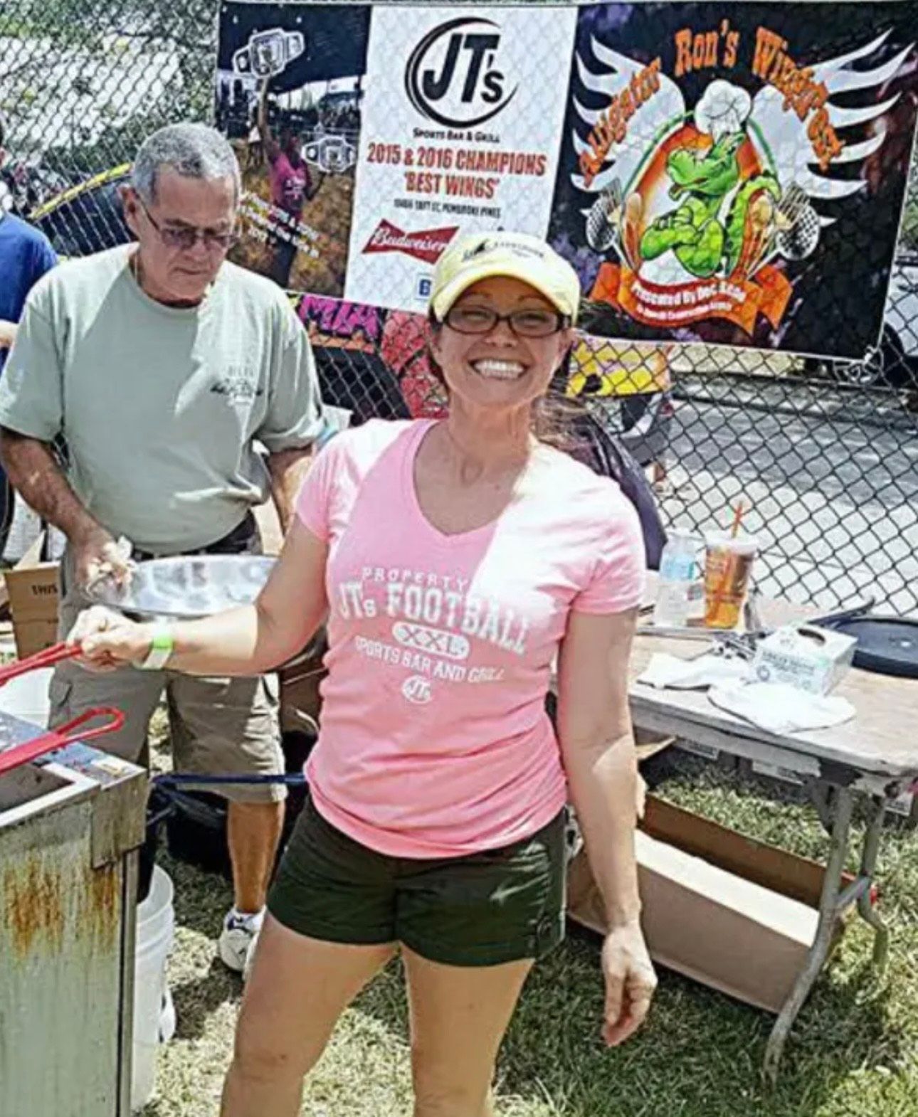 A woman wearing a pink shirt that says it 's football