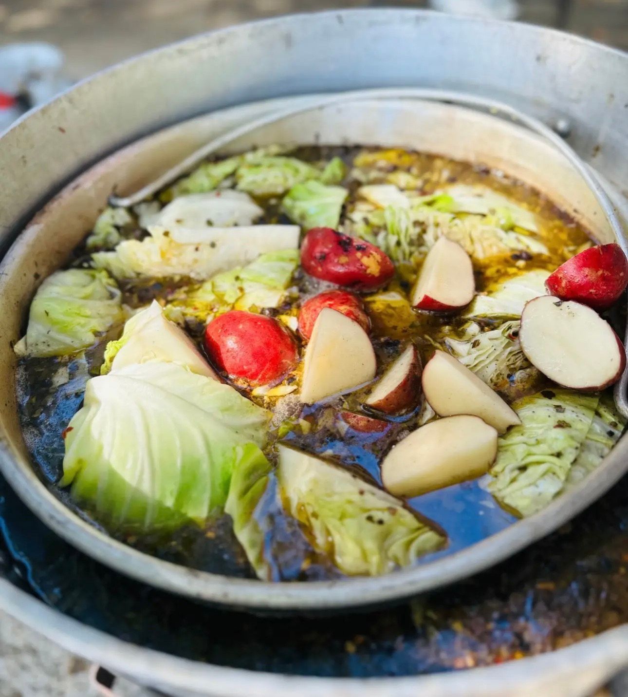 A pot of soup with cabbage and potatoes in it