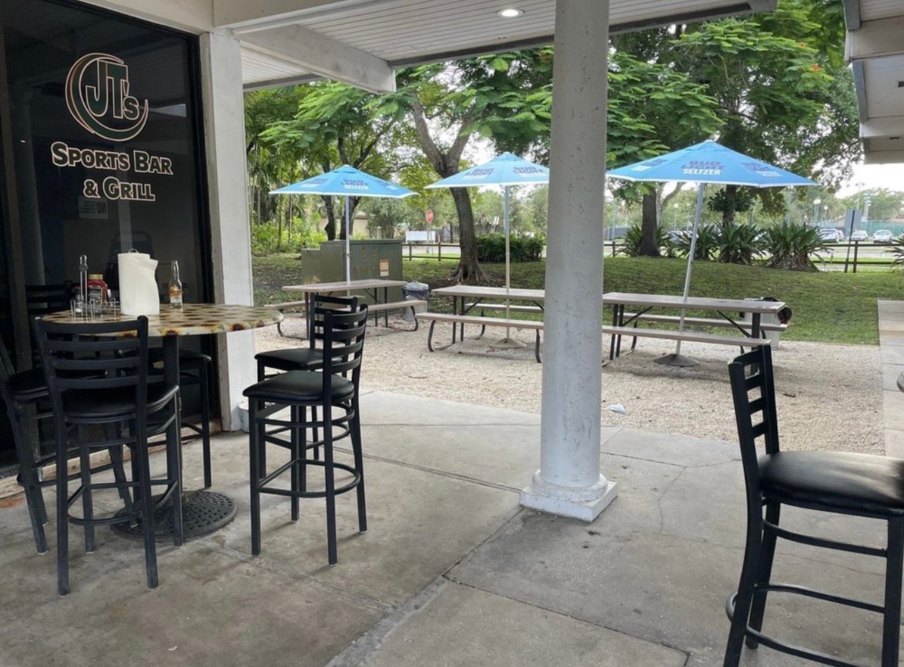 A restaurant with tables and chairs and umbrellas outside