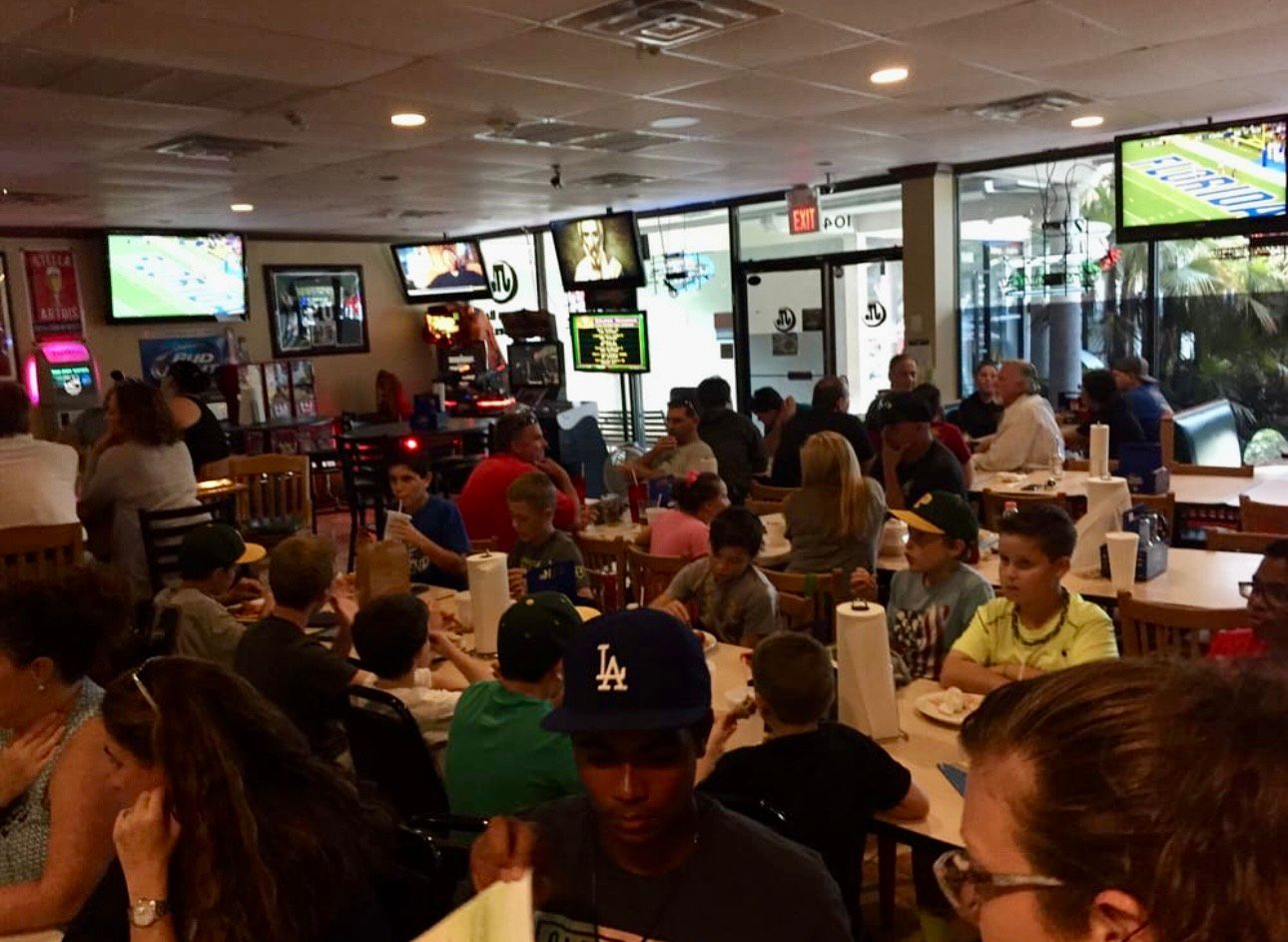 A man wearing a la hat sits at a table in a restaurant