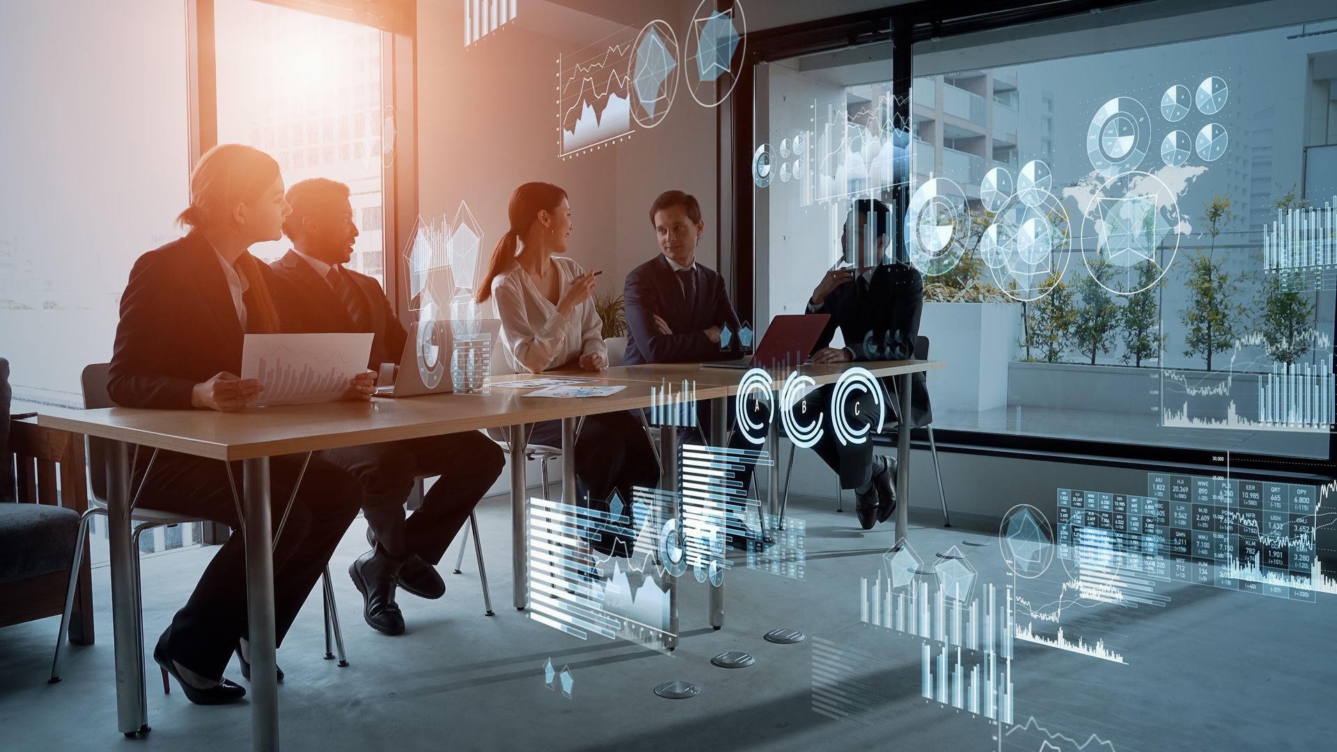 Business team in a modern office, discussing data with digital graphs overlaid.