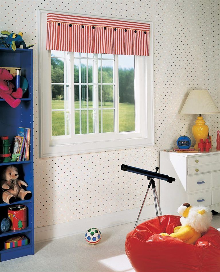 A child's room with a window, striped red valance, blue bookshelf, white dresser, telescope, and red beanbag chair.