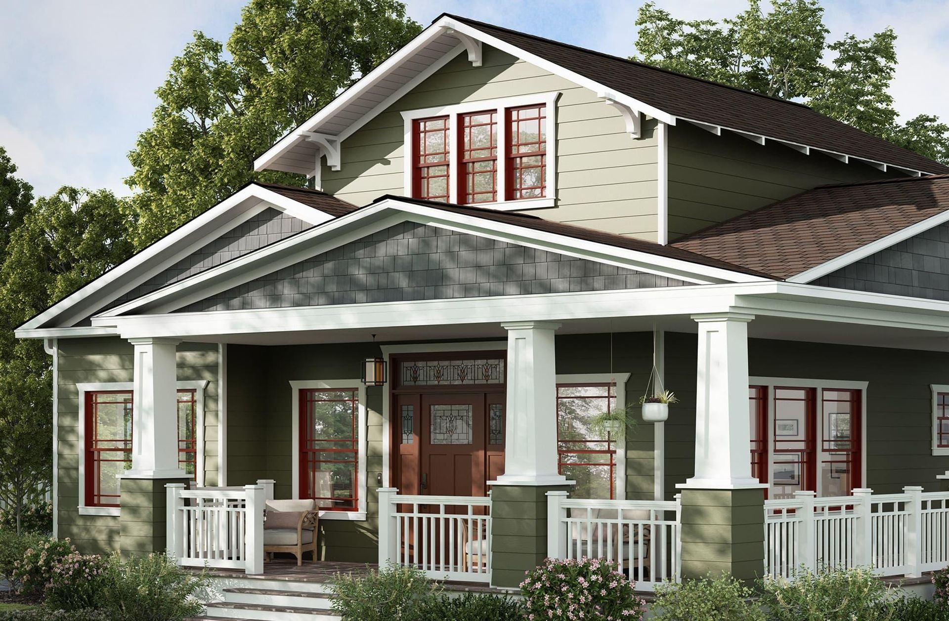 A green craftsman-style house with a covered front porch, white pillars, a dark wood front door, and a gabled roof.