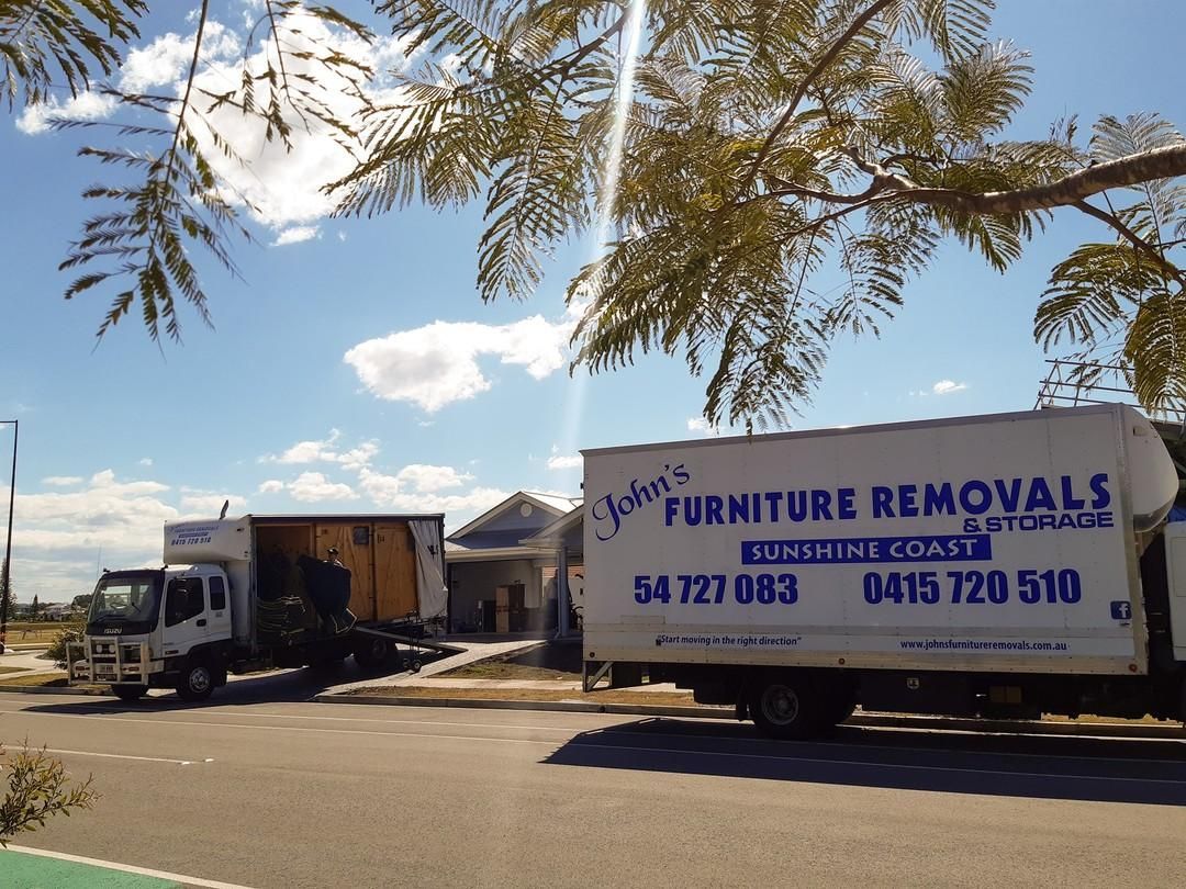 Two John's Furniture Removals Trucks Parked Near a House — John's Furniture Removals in Nambour, QLD