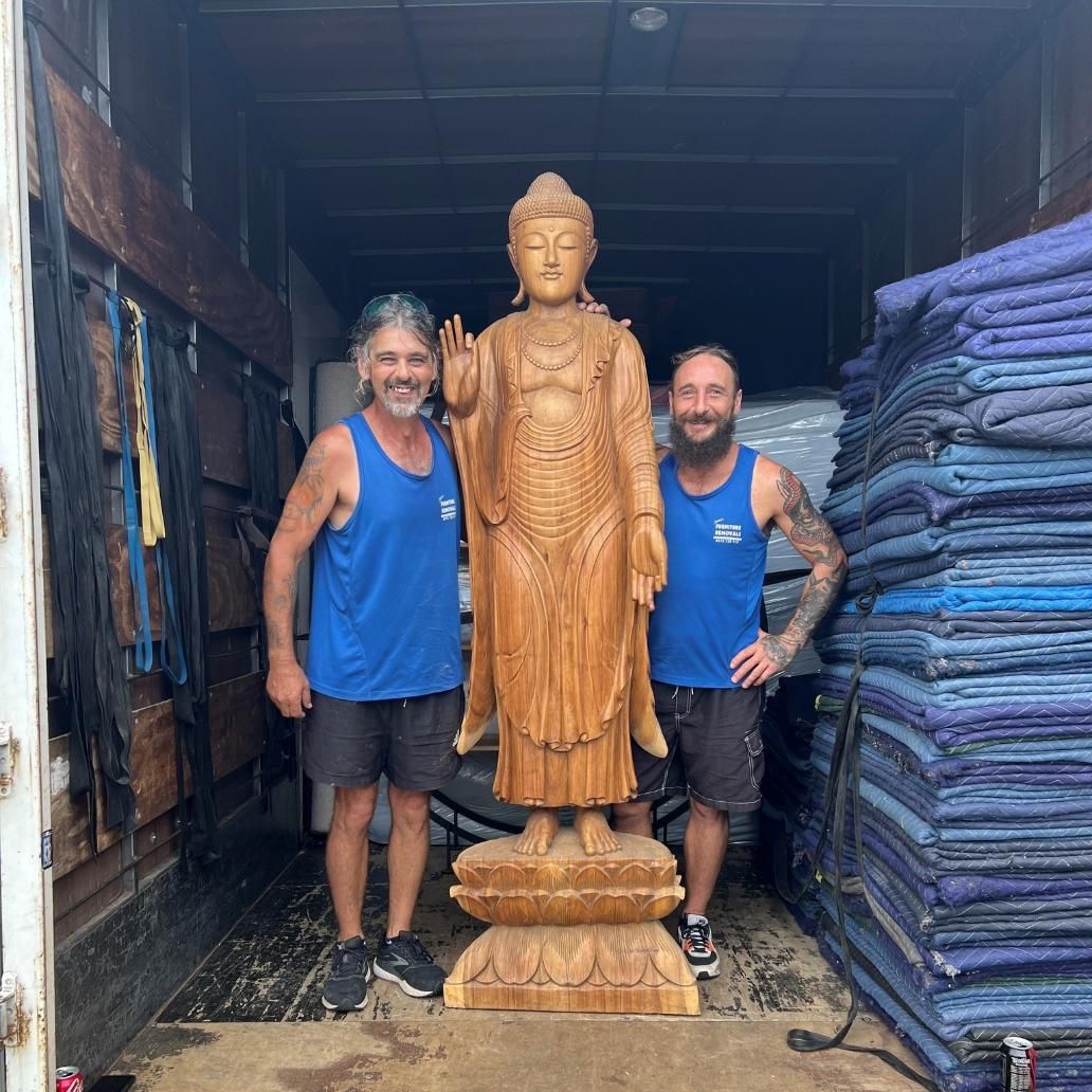 Two Men Stand With a Large Wooden Buddha Statue in a Truck — John's Furniture Removals in Sunshine Coast, QLD